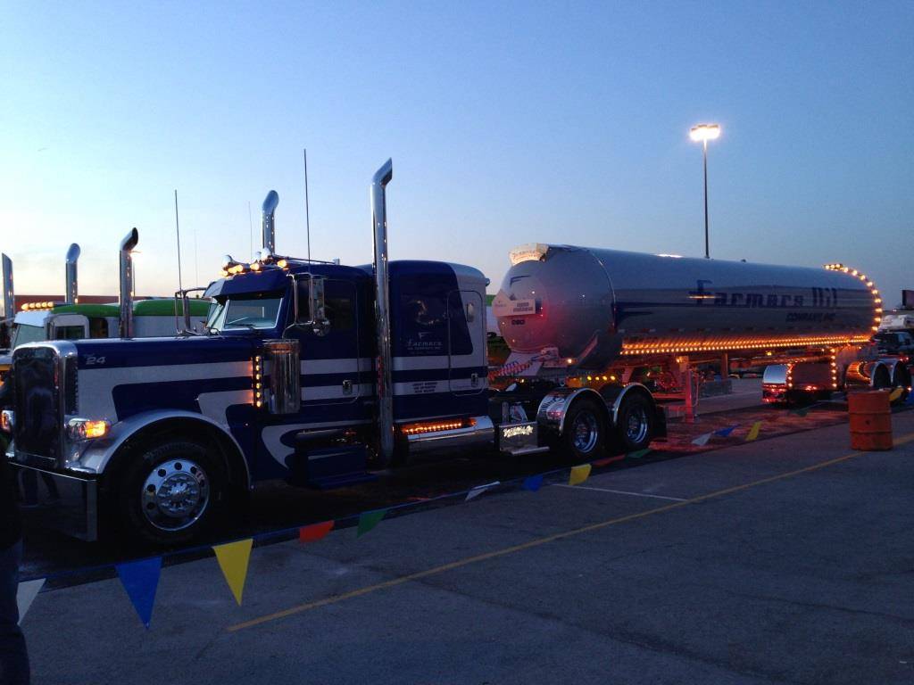 Silver Lining, a navy and chrome Farmers Oil Peterbilt and tanker lit up at the 2014 Mid-America Trucking Show