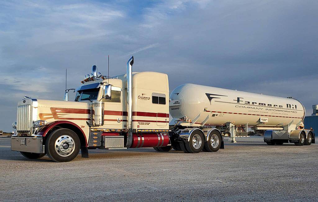 Cream Farmers Oil Peterbilt with maroon pinstripes pulling a white tank trailer