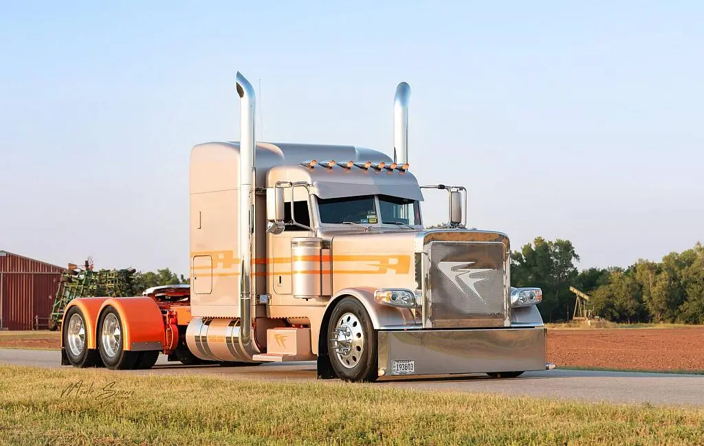 Cream and orange Farmers Oil Peterbilt tractor with tall chrome stacks